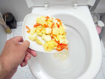 Person schmeißt Essensreste ins Klo. | © Getty Images / victorass88