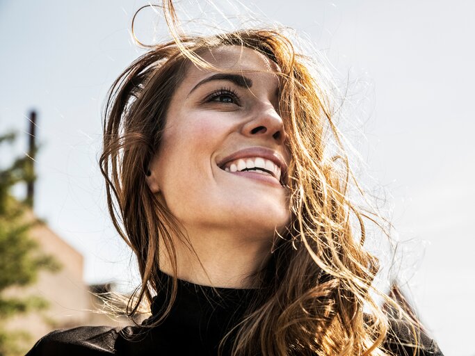  Porträt einer glücklichen Frau mit wehendem Haar | © GettyImages/Westend61