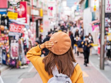 Frau mit Mütze steht in einer Straße in Tokyo | © Adobe Stock/Kittiphan