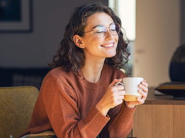 Junge Frau trinkt mit geschlossenen Augen ihren Kaffee | © gettyimages.de /  Ridofranz