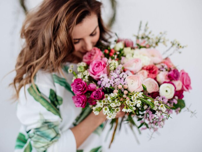 Frau mit buntem Blumenstrauß | © gettyimages.de /  Alina Kulbasnaia