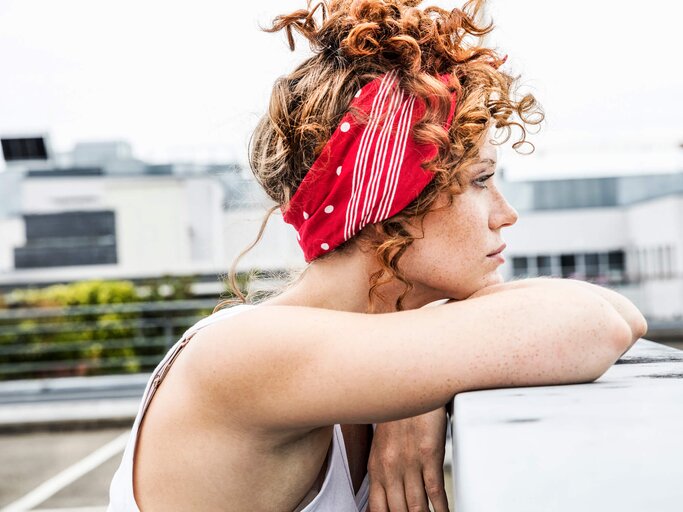 Frau mit Haarband blickt nachdenklich in die Ferne | © gettyimages.de / 	Westend61