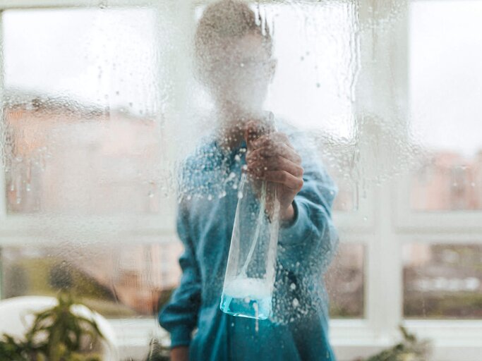 Frau sprüht Fensterglas ein | © Getty Images/Carol Yepes