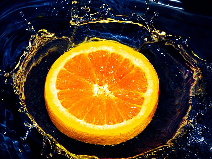 Orangenscheibe fällt ins Wasser | © Getty Images/Carlos. E. Serrano