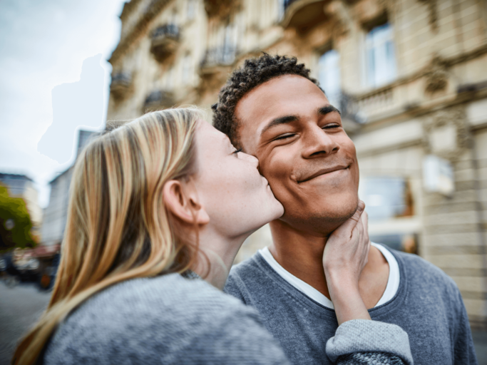 Frau küsst Mann auf die Wange | © Getty Images/Oliver Rossi