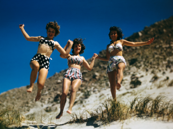 Drei Frauen springen am Strand | © Getty Images/Bettmann