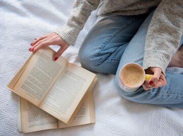 Buch und Kaffeetasse von oben fotografiert | © Getty Images/Jamie Grill