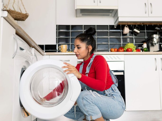 Frau schaut in Waschmaschine | © Getty Images/jose carlos cerdeno martinez