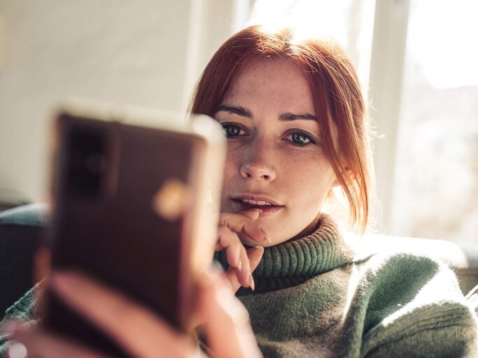 Frau schaut auf Smartphone | © Getty Images/Guido Mieth