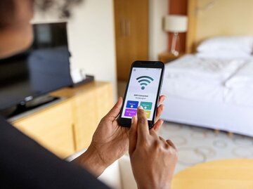 Frau hält Handy mit Wlan Zeichen in der Hand | © Getty Images/Luis Alvarez