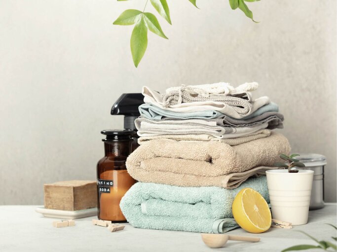 Gefaltete Wäsche mit Waschprodukten und Zitrone | © Getty Images/klenova