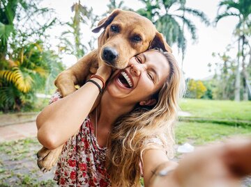 Junge Frau macht ein Selfie mit ihrem hellbraunen Labrador. | © Getty Images / Circle Creative Studio