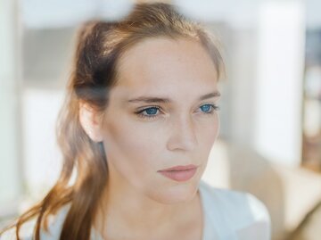 Eine junge Frau schaut nachdenklich | © GettyImages/Guido Mieth