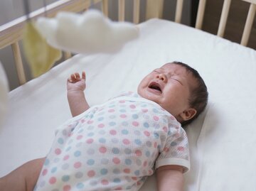 Ein Baby schreit in seinem Bettchen | © GettyImages/prpicturesproduction
