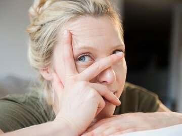 Blonde Frau verdeckt ihr Gesicht mit einer Hand | © Getty Images/Jamie Grill