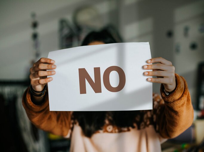 Frau hält ein Schild mit "NO" nach oben | © Getty Images/Carol Yepes
