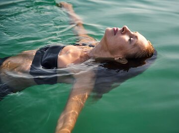 Frau liegt entspannt im Wasser  | © Getty Images/Westend61