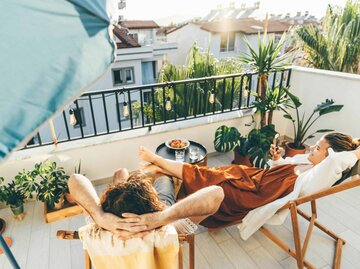 Junges Paar entspannt auf dem Balkon | © Getty Images/Maria Korneeva