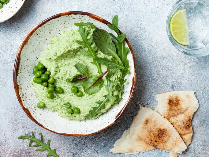 Eine Schüssel mit grünem Dip aus Erbsen und Ruccola | © Getty Images/sveta_zarzamora