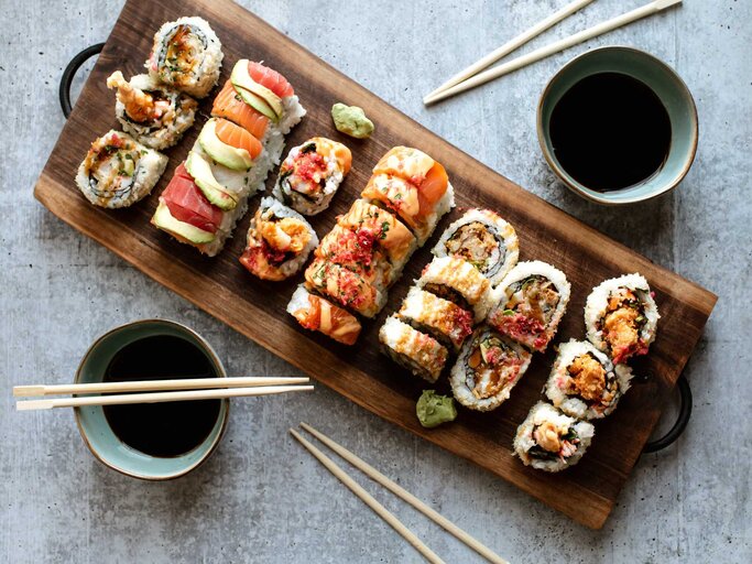 Ein Brett mit Sushi und zwei Schüsseln dunkler Fischsauce | © Getty Images/Cavan Images