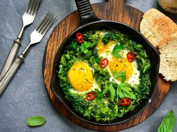 Eine Gusseinenpfanne mit Spinat, Spiegeleiern und Feta (grünes Shakshuka) | © Getty Images/Lilechka75