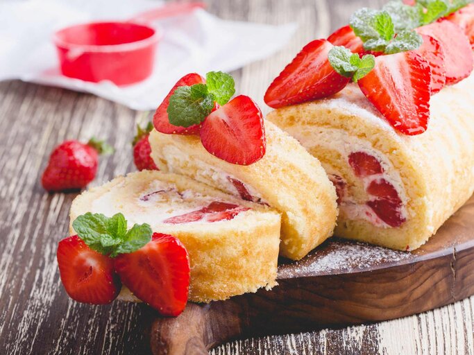 Erdbeer-Biscuitrolle mit feiner Creme und frischen Erdbeeren | © Getty Images/istetiana
