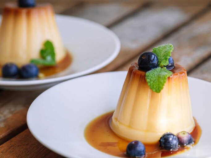 Kokos-Flan mit frischen Früchten und Karamell Soße | © Getty Images/maitetxu