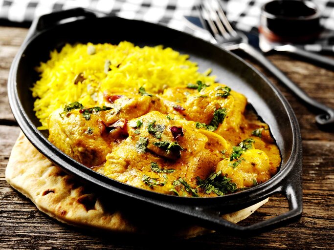 Eine gusseiserne Pfanne mit Chicken Korma | © Getty Images/Joff Lee