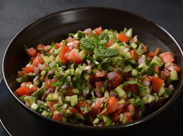 Tomaten-Gurken-Salat in dunkler Salatschüssel | © GettyImages/Nataly Hanin
