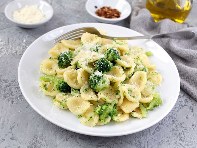 Teller mit Brokkolipasta steht auf dem Tisch und eine Gabel liegt daneben. | © Getty Images / Ale02