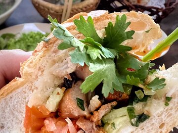 Nahaufnahme eines vietnamesischen Banh Mi-Sandwichs mit Hühnerfleisch und grünem Gemüse als Füllung | © Getty Images/Calvin Chan Wai Meng