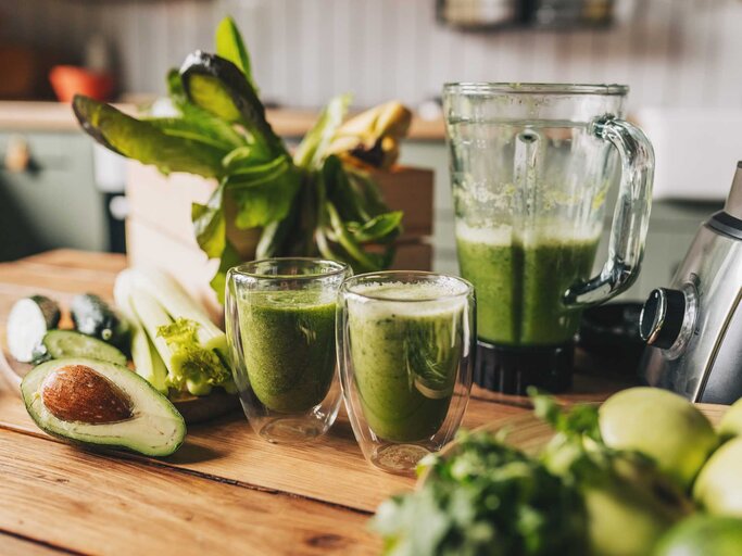 Gesunder grüner Smoothie mit Banane, Spinat, Avocado und Chiasamen in Glasflaschen auf rustikalem Hintergrund | © Getty Images/Kseniya Ovchinnikova