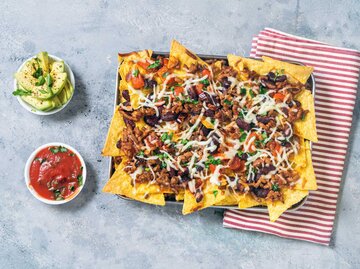 Ein Teller überbackende Nachos mit zwei separaten Soßen | © Getty Images/Carlo A