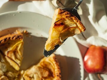 Ein Stück Apfelkuchen wir über den Tisch gereicht | © unsplash/dilja96