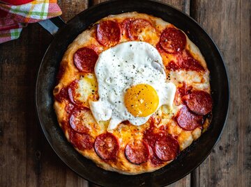 Pizza mit Salami und Ei | © Getty Images/heinstirred