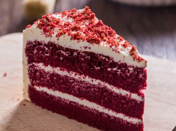Ein Stück red velvet Cake auf einem Brett | © Adobe Stock/paulfourk