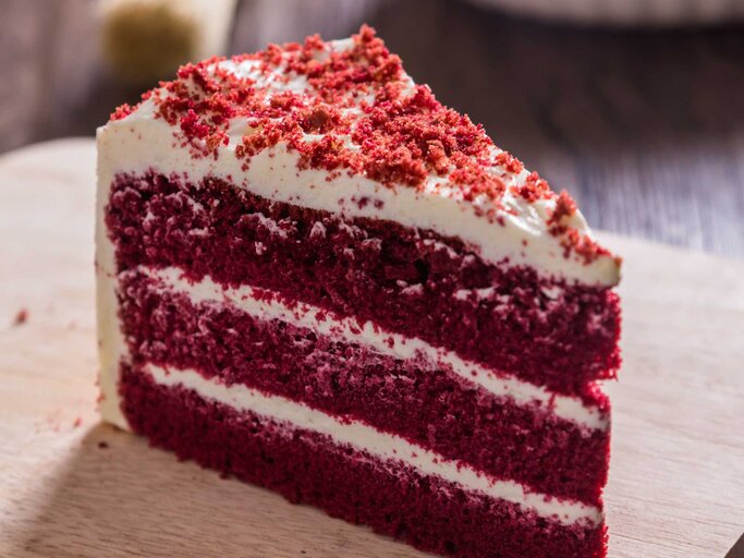Ein Stück red velvet Cake auf einem Brett | © Adobe Stock/paulfourk