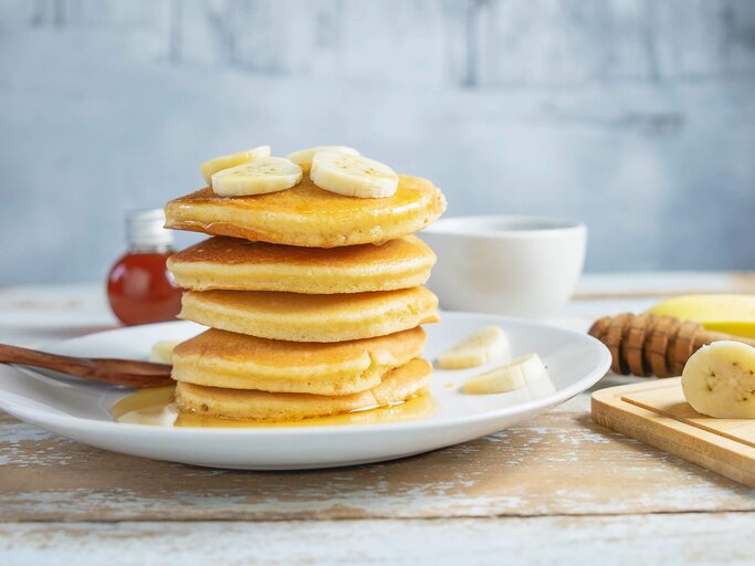 Bananen Pancakes schön auf einem Teller angerichtet | © gettyimages.de / Narong KHUEANKAEW