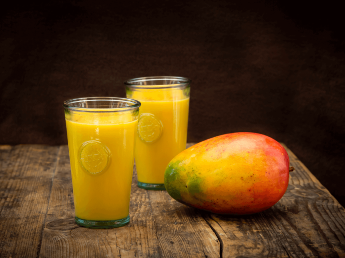 Zwei Gläser mit Mango Lassi und einer Mango | © Getty Images/Antoniu Rosu 