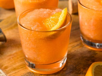 Frozen Aperol Spritz in Tumblerglas serviert | © Getty Images/bhofack2