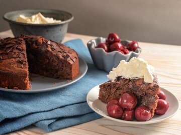Saftiger Schoko-Kirsch-Kuchen mit Sahne serviert | © Getty Images/fermate