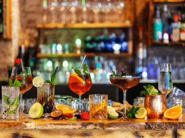 Verschiedene Cocktails auf einem Bar-Tresen | © Getty Images/Yulia-Images