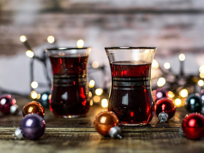 Zwei Tassen mit Glühwein und Weihnachtskugeln | © Getty Images/lacaosa