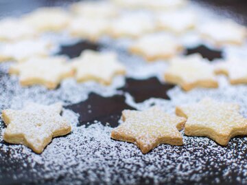 Plätzchen auf einem Blech mit Puderzucker bestreut | © Getty Images/Tanja Esser/EyeEm