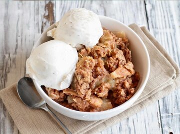 Frisch heißer hausgemachter Apfel knusprig oder bröckelt mit knusprigem Streusel-Topping mit Vanillebohneneis | © Getty Images/StephanieFrey