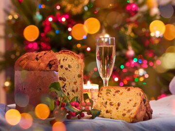 Angeschnittener Panettone vor Christbaum | © Getty Images/ac productions