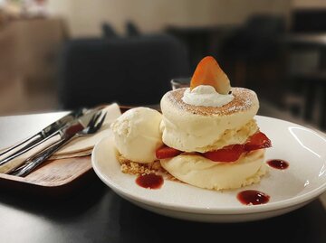 Japanische Pancakes mit Vanilleeis und frischen Erdbeeren auf einem weißen Teller. | © Getty Images / Vorawan Chittpayak / EyeEm