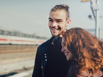 Junges Paar verliebt am Bahnhof | © Getty Images/Guido Mieth