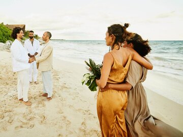 Zwei Personen in Kleidern am Strand bei Hochzeit | © Getty Images/Thomas Barwick