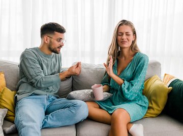 Paar sitzt auf der Couch und streitet | © Getty Images/Eleganza